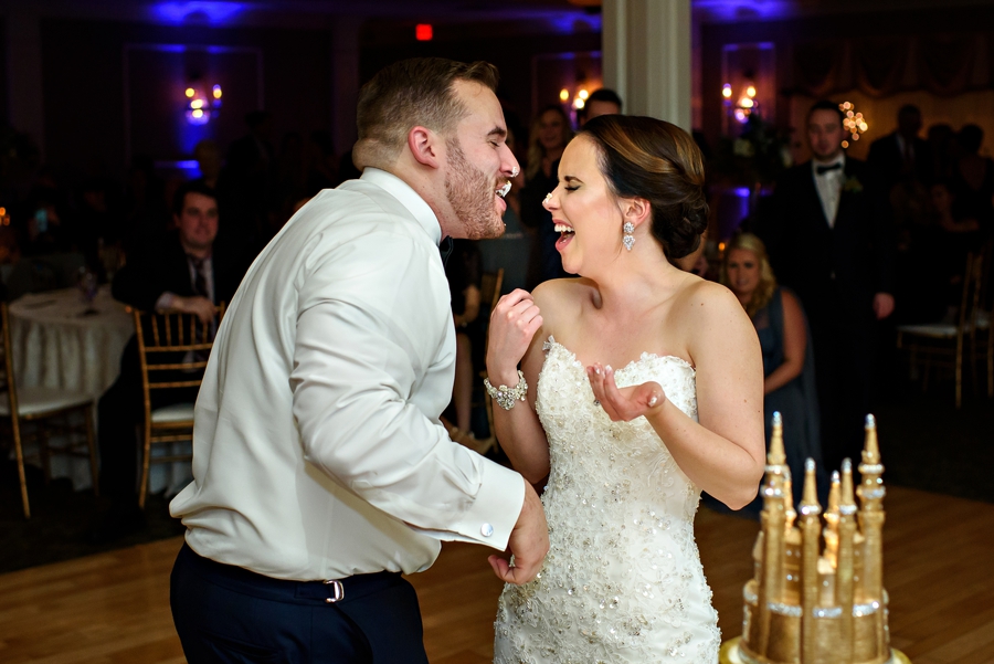 A groom eats cake off his bride's nose at their wedding reception.